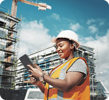 Woman at a construction site looking at a clipboard 